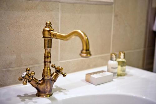 un grifo de oro en un lavabo en el baño en Hotel Villa Grace, en Međugorje