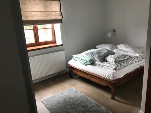 a bedroom with a bed with pillows and a window at Chata rybacka w Orłowie / Apartament in Gdynia