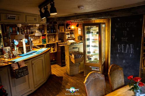 a bar with a counter and chairs and a refrigerator at The Bear Inn in Llandovery