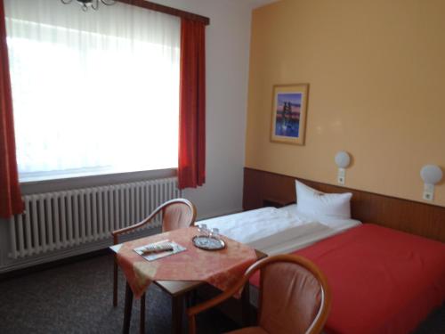 ベルリンにあるHotel Südenのベッドとテーブルが備わるホテルルームです。