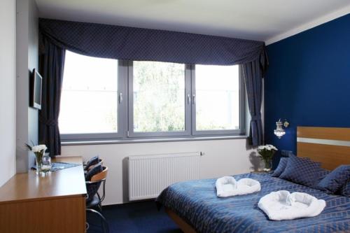 プラハにあるホテル U カーラの青いベッドルーム(ベッドにタオル2枚付)