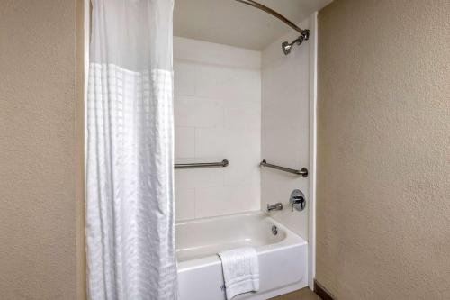 a bathroom with a white shower curtain and a bath tub at Comfort Suites Baymeadows Near Butler Blvd in Jacksonville