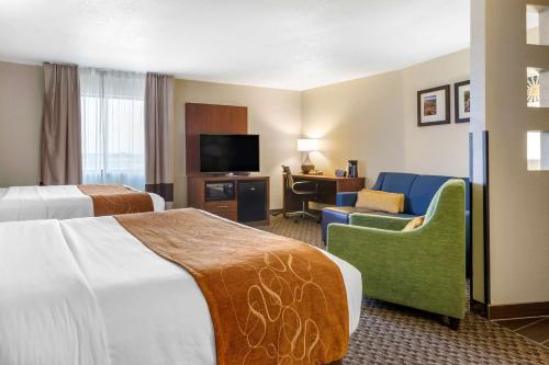 a hotel room with two beds and a television at Comfort Suites Hobbs in Hobbs