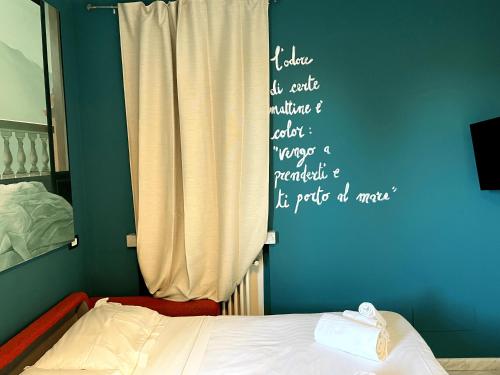 a bedroom with a bed and a wall with writing on it at Confortevole monolocale a 500 mt dal mare in Marina di Carrara