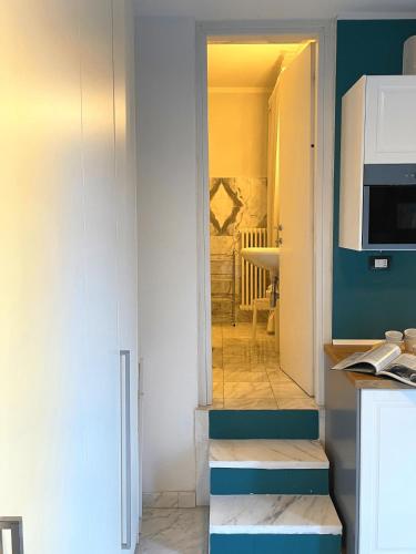 eine Küche mit blauen und weißen Wänden und einer Mikrowelle in der Unterkunft Confortevole monolocale a 500 mt dal mare in Marina di Carrara