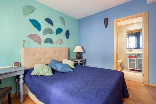 - une chambre dotée d'un mur bleu et d'un lit avec des oreillers dans l'établissement FORUM BEACH 2 AND POOL APARTMENT BARCELONA, à Barcelone