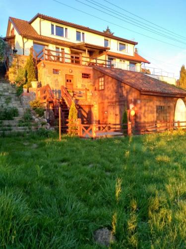 a large house on top of a green field at Gościniec Pod Lipą in Mikołajki