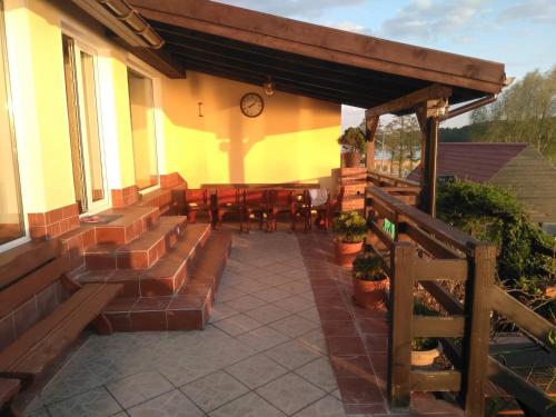 a patio with a table and chairs and a clock at Gościniec Pod Lipą in Mikołajki