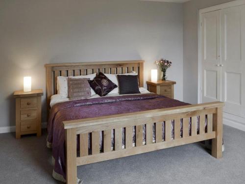 a bedroom with a wooden bed with two night stands at The Old Farmhouse at Mena in Bodmin
