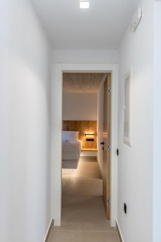 a bedroom with white walls and a bed in the distance at Blue Gres Villa Tinos in Tinos Town