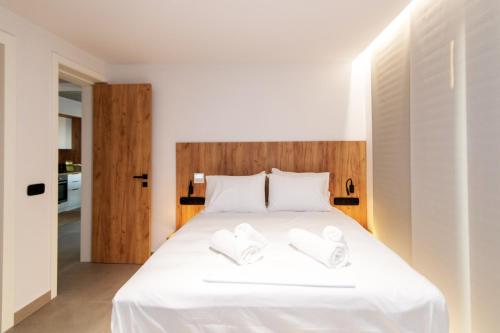 a bedroom with a white bed with two white towels at Blue Gres Villa Tinos in Tinos Town