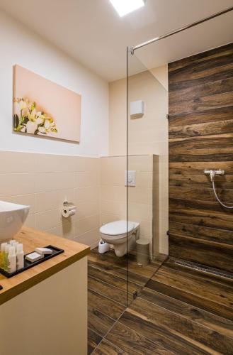 a bathroom with a toilet and a glass shower at Kistücsök Food & Room in Balatonszemes