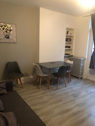 un salon avec une table et des chaises dans l'établissement Appartement F3 agréable, à Vichy