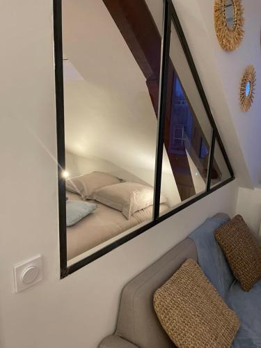 espejo en una habitación con cama y silla en L'amiral n5 T2 dernier étage ByLocly, en Lorient