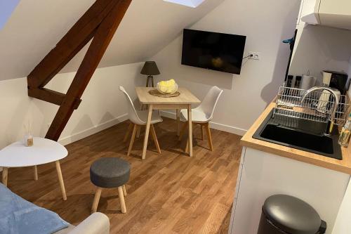 una pequeña sala de estar con mesa y TV. en L'amiral n5 T2 dernier étage ByLocly, en Lorient