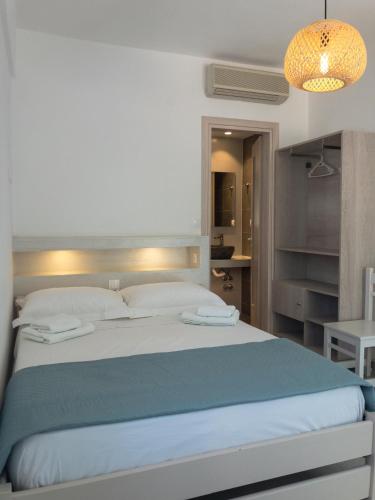 a bedroom with a large bed with a blue blanket at Golden Sun in Ios Chora