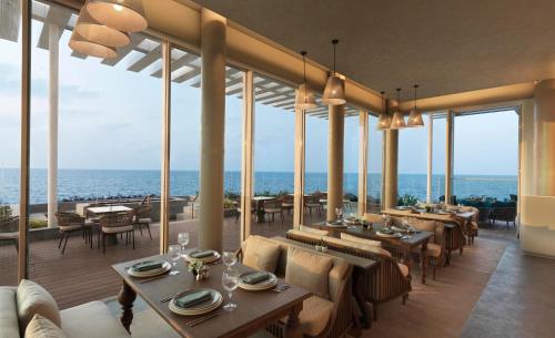 a restaurant with tables and chairs and a view of the ocean at InterContinental Ras Al Khaimah Mina Al Arab Resort & Spa by IHG in Ras al Khaimah
