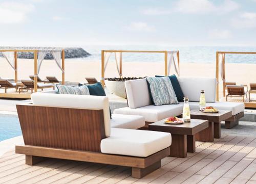 a patio with couches and tables on the beach at InterContinental Ras Al Khaimah Mina Al Arab Resort & Spa by IHG in Ras al Khaimah