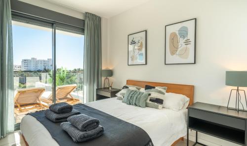 a bedroom with a bed with towels on it at AR 17 South Bay in Estepona