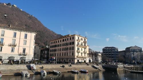L'Approdo di Sant'Agostino في كومو: مدينة بها مباني وقوارب في الماء