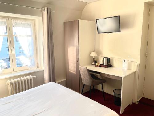 a hotel room with a desk and a bed at Hôtel - Restaurant "Histoire de Bistrot" in Isbergues