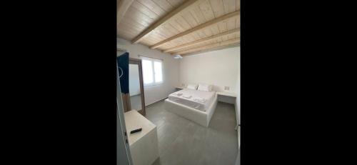 a white bathroom with a sink and a window at Villa & Suite Elia Mykonos in Mikonos