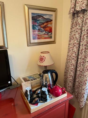 a table with a tea kettle and a lamp on it at Dana Villa Holiday Accommodation in Oban