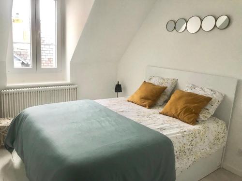 een slaapkamer met een groot bed met 2 kussens bij Cristal House in Trouville-sur-Mer
