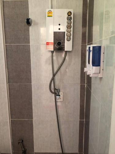 a bathroom with a shower with a phone on the wall at มุกดาสวรรค์ รีสอร์ท - Mukda Sawan Resort in Mukdahan
