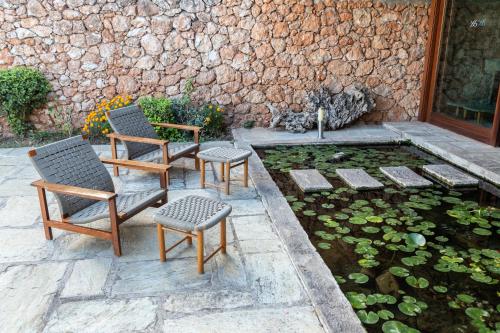 a patio with two chairs and a pond with lilies at Amalia Hotel Delphi in Delfoi