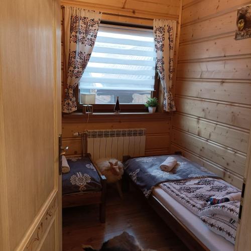 mały pokój z 2 łóżkami i oknem w obiekcie Apartament w Zagrodzie w mieście Frydman