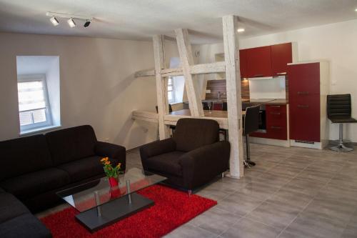 a living room with a couch and a loft bed at Appartements Le Hupsa Pfannala in Saint-Hippolyte