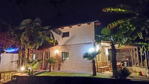 a home at night with palm trees and lights at Holiday Home Casa Salina in Sečovlje
