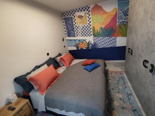 a bedroom with a bed with orange and blue pillows at Sandy's Superior Suite in Ancient Epidavros
