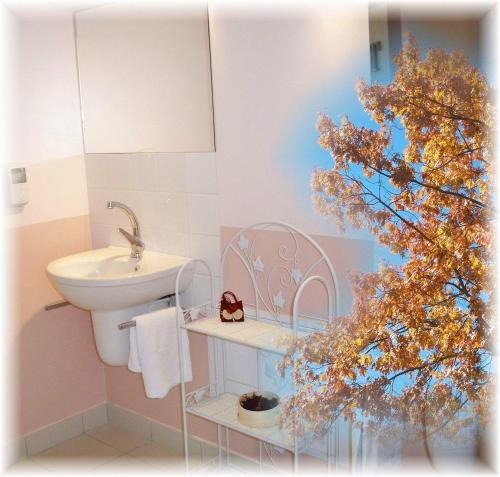 a bathroom with a sink and a toilet and a tree at Natur'Hôtel in Ménesplet