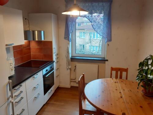 une cuisine avec une table, une fenêtre, une table et des chaises dans l'établissement Honeymoon Guesthouse, à Helsingborg