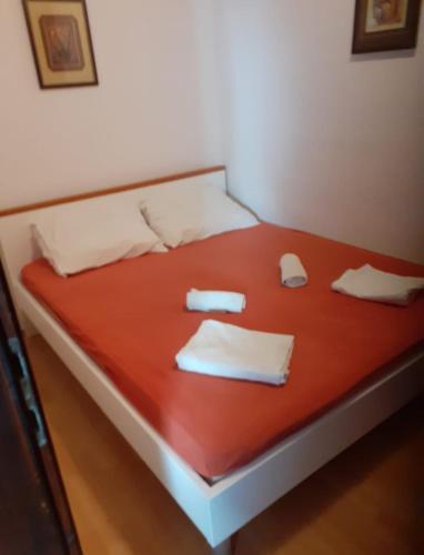 a bed with red sheets and white towels on it at Josip 1 Gajac in Novalja