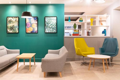 a waiting room with chairs and a green wall at Holiday Inn Southampton Eastleigh by IHG in Southampton