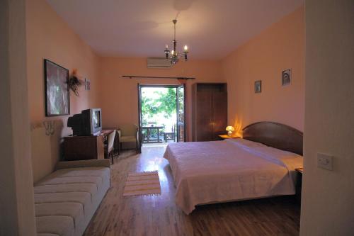 a bedroom with a bed and a couch and a television at Apartments Magda in Cavtat