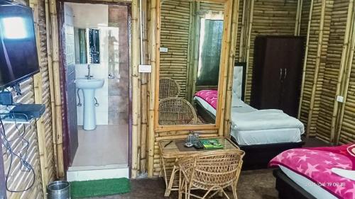 una camera con un letto e un tavolo di Dhanaulti Jungle Resort a Dhanaulti