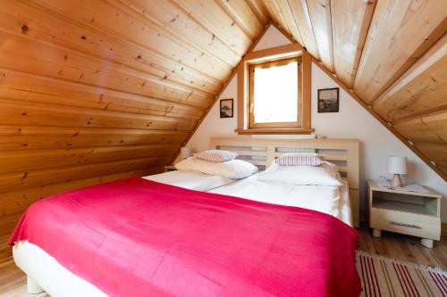 ザコパネにあるDomek Bachledówka Zakopaneの木造キャビン内のベッドルーム1室(ベッド2台付)