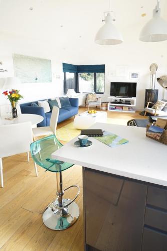 a kitchen and living room with a white counter top at Seagrass - Ventnor in Ventnor