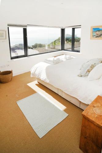 a white bedroom with a large bed and a window at Seagrass - Ventnor in Ventnor