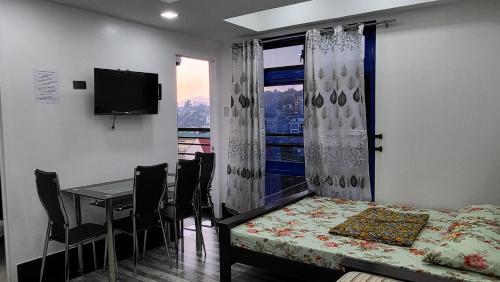 a dining room with a table and a window at Finteo Skylands Premium in Baguio