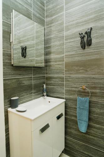 a bathroom with a white sink and a mirror at Seagrass - Ventnor in Ventnor