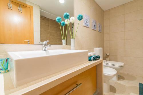 a bathroom with a sink and a toilet with blue balloons at Cabanas Gardens by Algartur in Cabanas de Tavira