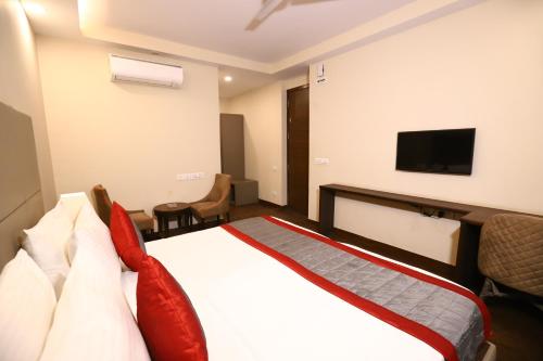 a hotel room with a bed and a flat screen tv at Hotel Azulo Inn Bhikaji Cama Place Delhi in New Delhi