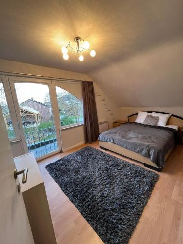 a bedroom with a bed and a large window at Le grand marronnier in Neuville