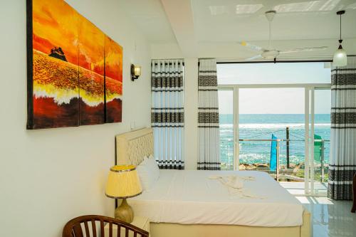 sypialnia z łóżkiem i widokiem na ocean w obiekcie Chanro Surf Dream w mieście Matara