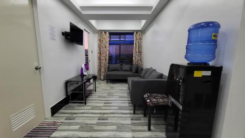 a hallway with a living room with a blue bucket on top at Finteo Skylands Premium in Baguio